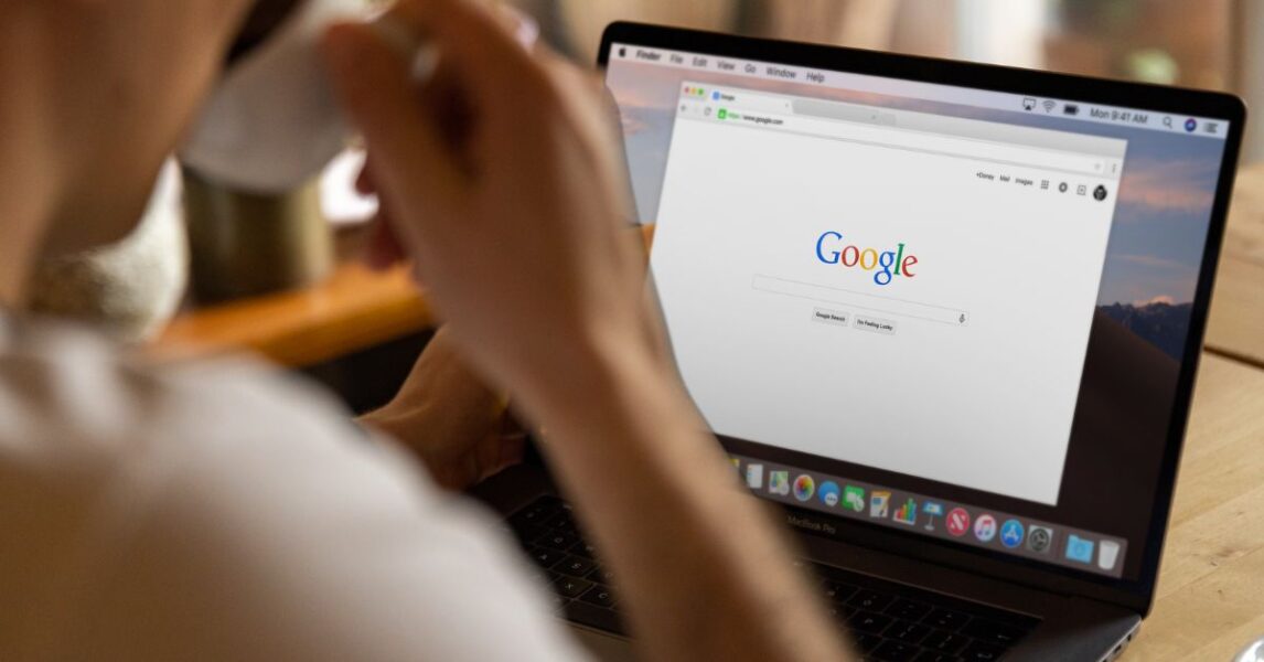 Person on laptop, on Google, with a cup of tea/coffee in hand